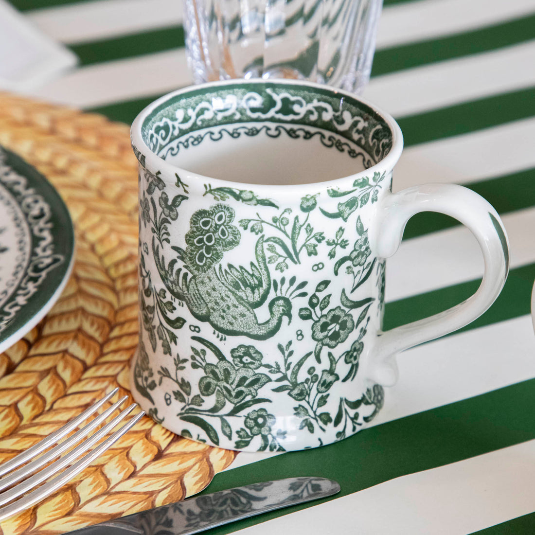 A table setting with a green and white place setting that features Burleigh&