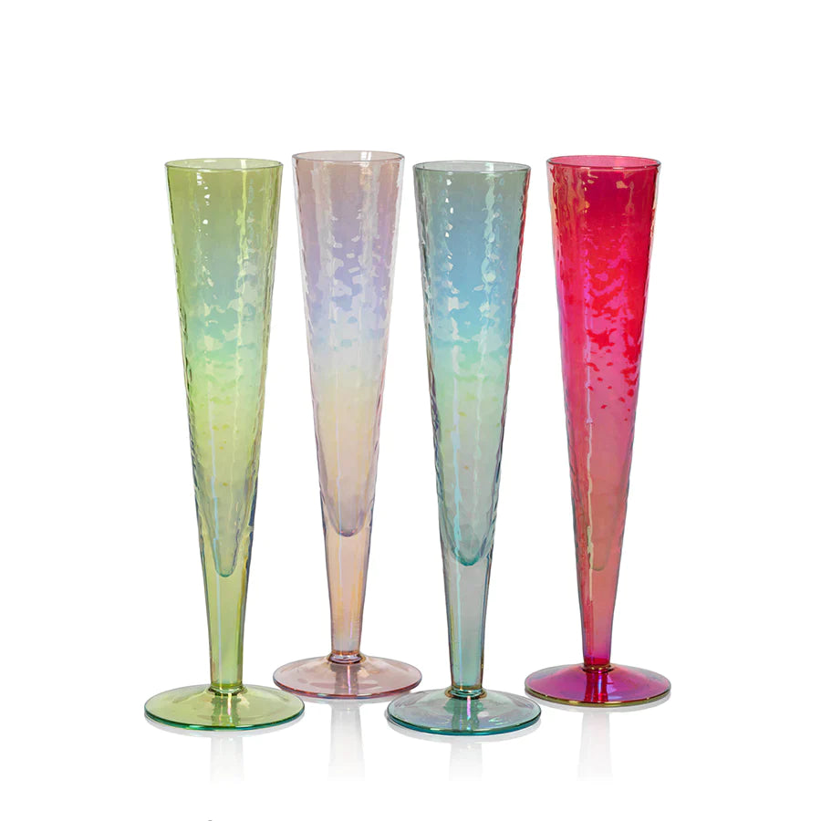 Four Zodax Luster Slim Champagne Flute Glassware with a champagne bottle in an ice bucket in the background.