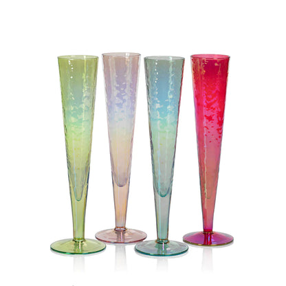 Four Zodax Luster Slim Champagne Flute Glassware with a champagne bottle in an ice bucket in the background.