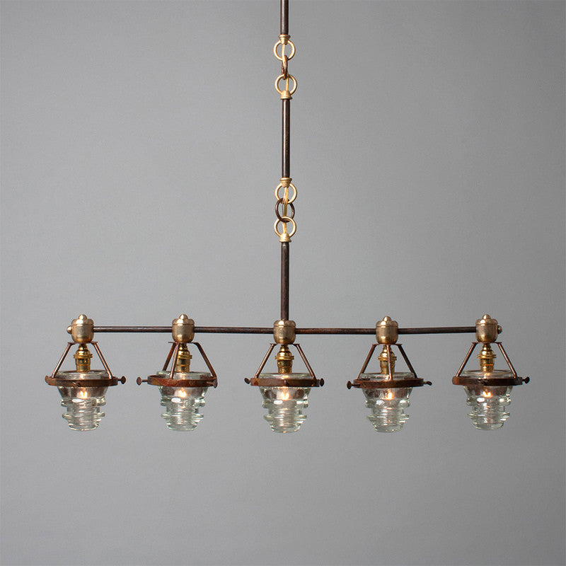 A Telegraph Pendant Lighting with four glass shades and antique insulators hanging from a brass frame. (Brand Name: Hester &amp; Cook)