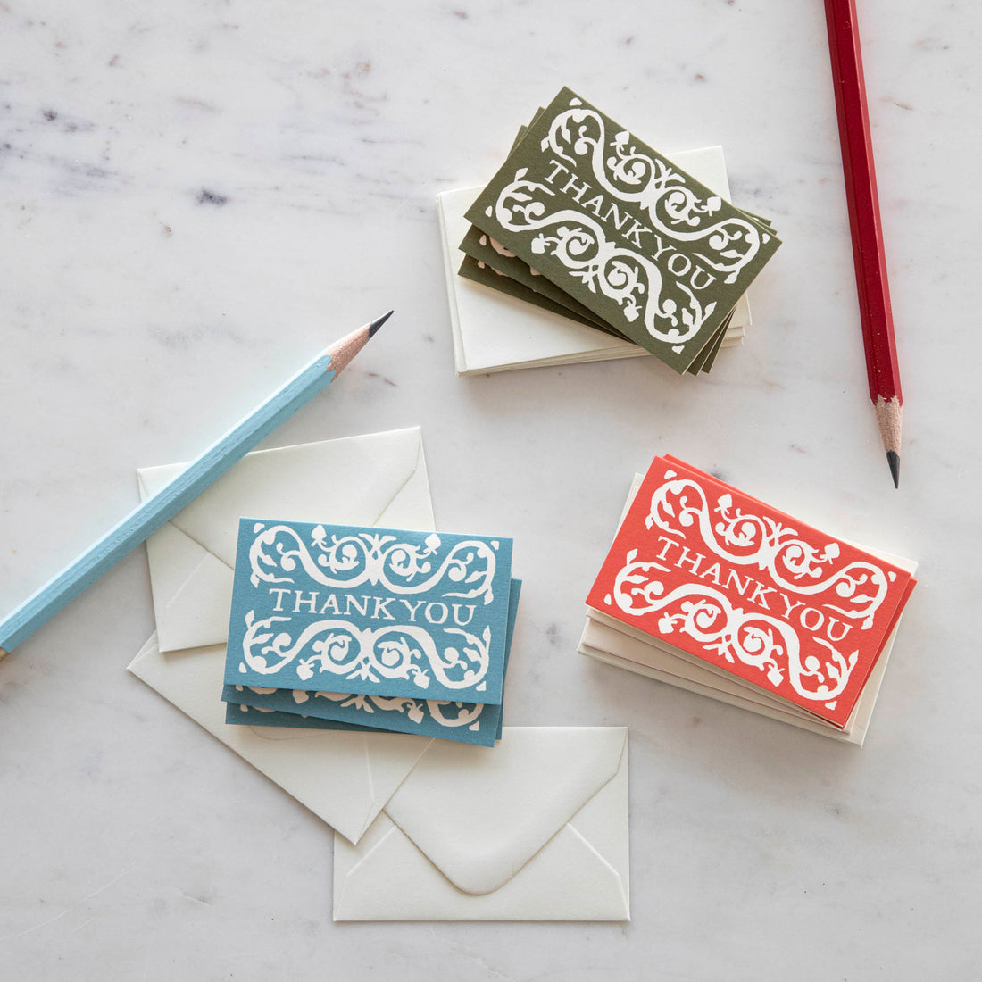 A selection of Cambridge Imprint Arabesque Thank You Cards with intricate designs next to two pencils, crafted on FSC-certified stock.