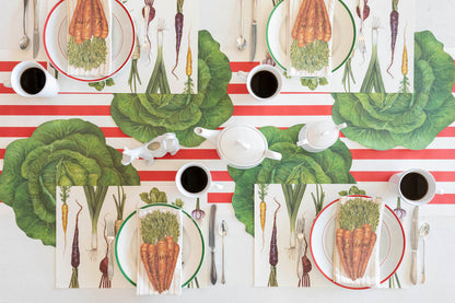 A vegetable-themed table setting featuring Carrots Table Accents resting on each plate with names written on them, from above.