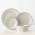 A set of fine stoneware plates and bowls from the Luzia Ash Grey Round Dinnerware collection by Costa Nova on a white surface, perfect for a modern table setting.
