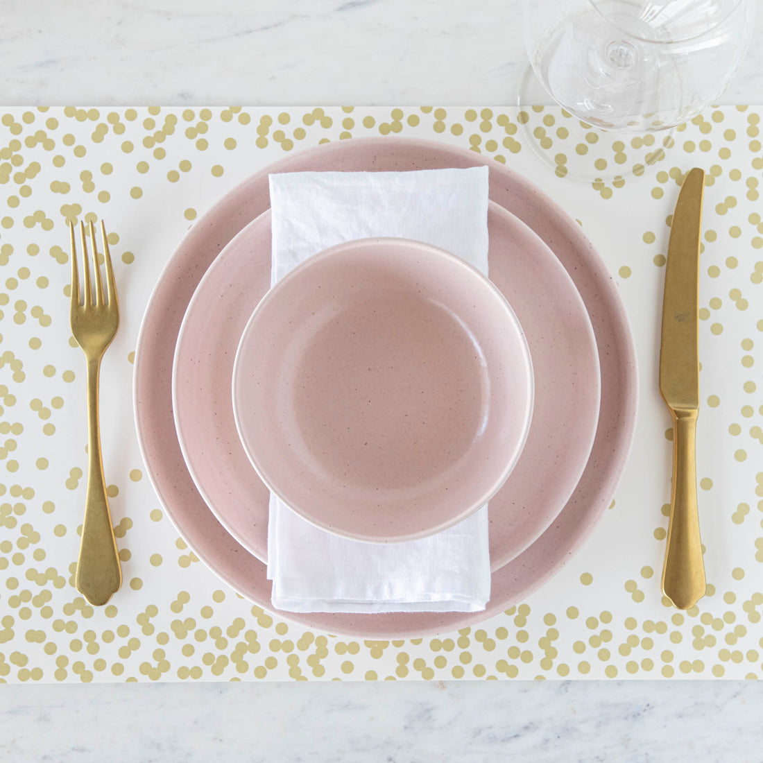 Pink and gold placemat from the Pacifica Marshmallow Dinnerware collection by Casafina Living.