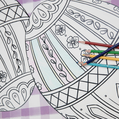 Close-up of the Die-cut Coloring Easter Egg Placemat on an Easter-themed table setting, partially filled in with colored pencils.