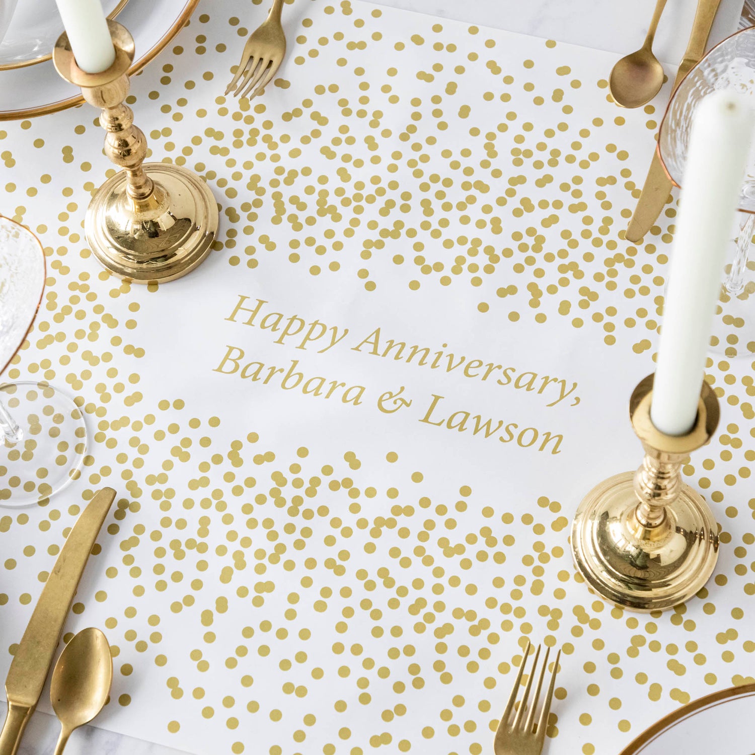 The Gold Confetti Personalized Runner under an elegant table setting, with &quot;Happy Anniversary, Barbara &amp; Lawson&quot; printed in gold in the center.