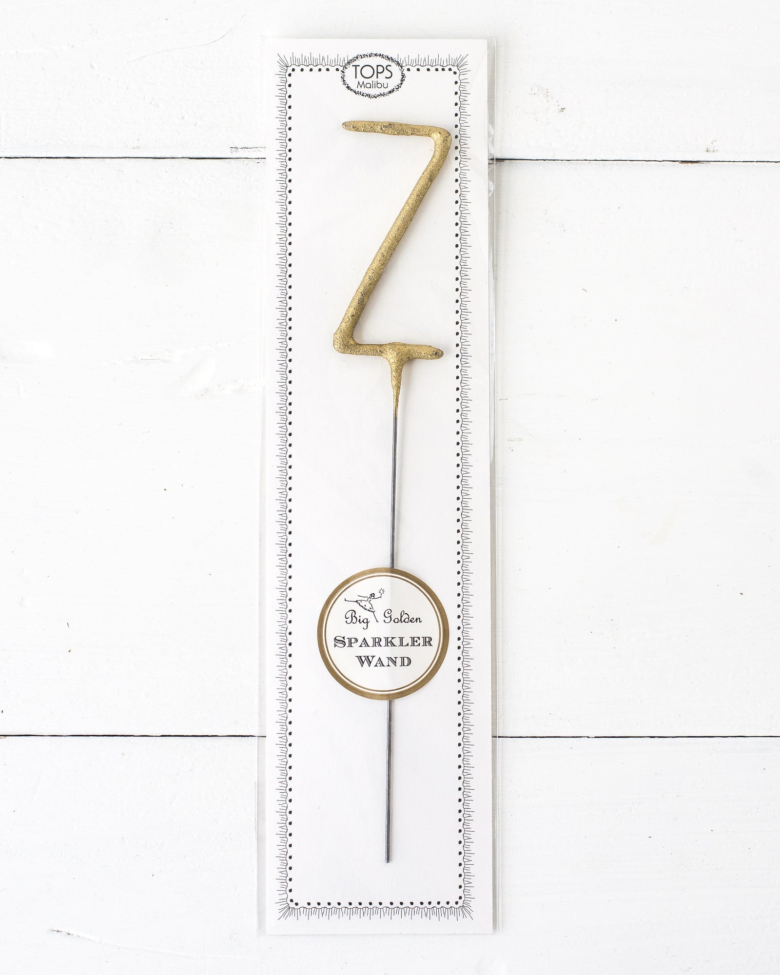 Three Tops Malibu gold Letter Sparklers on a wooden surface.