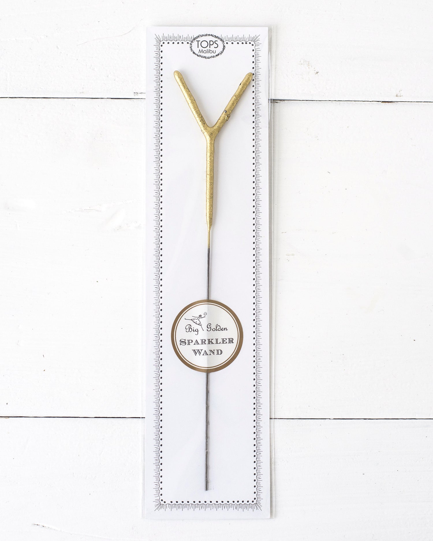 Three Tops Malibu gold Letter Sparklers on a wooden surface.