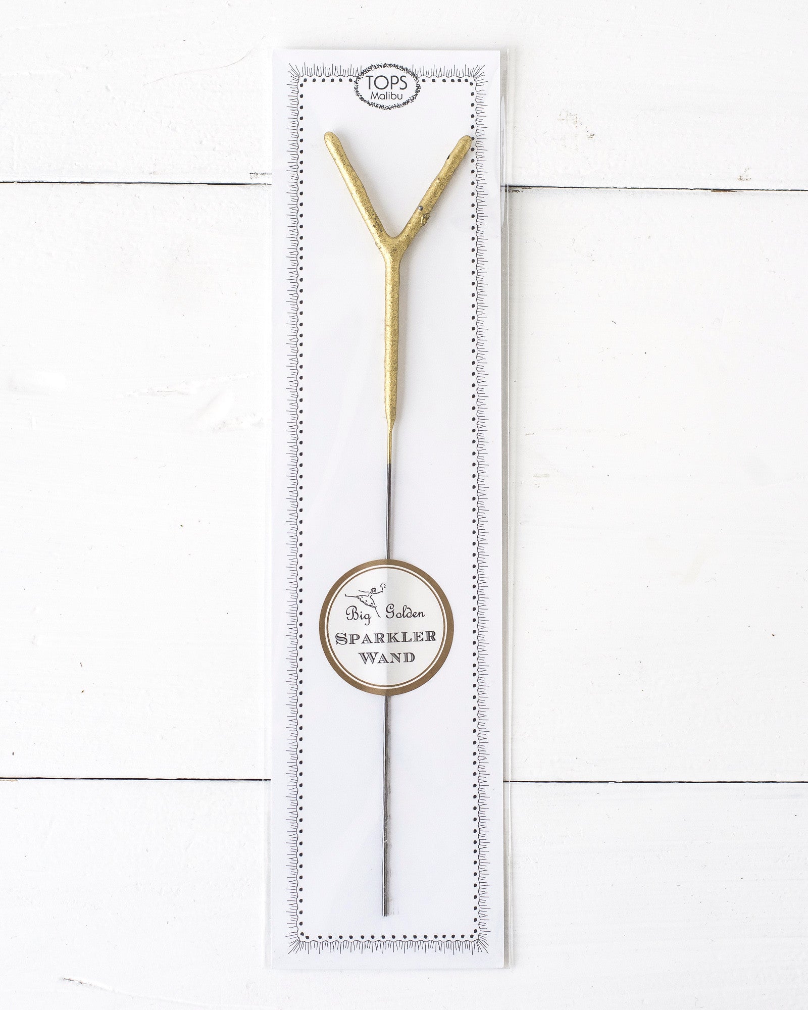 Three Tops Malibu gold Letter Sparklers on a wooden surface.