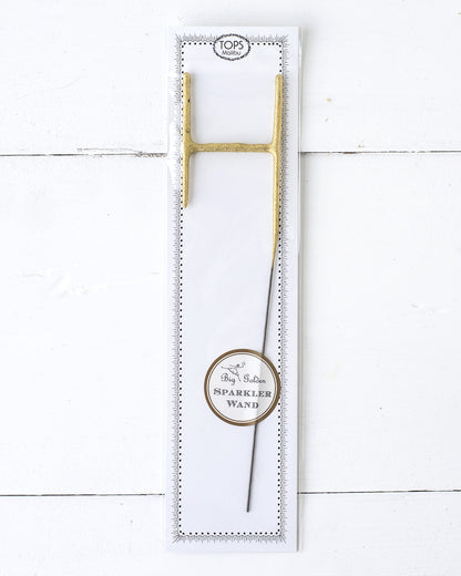 Three Tops Malibu gold Letter Sparklers on a wooden surface.