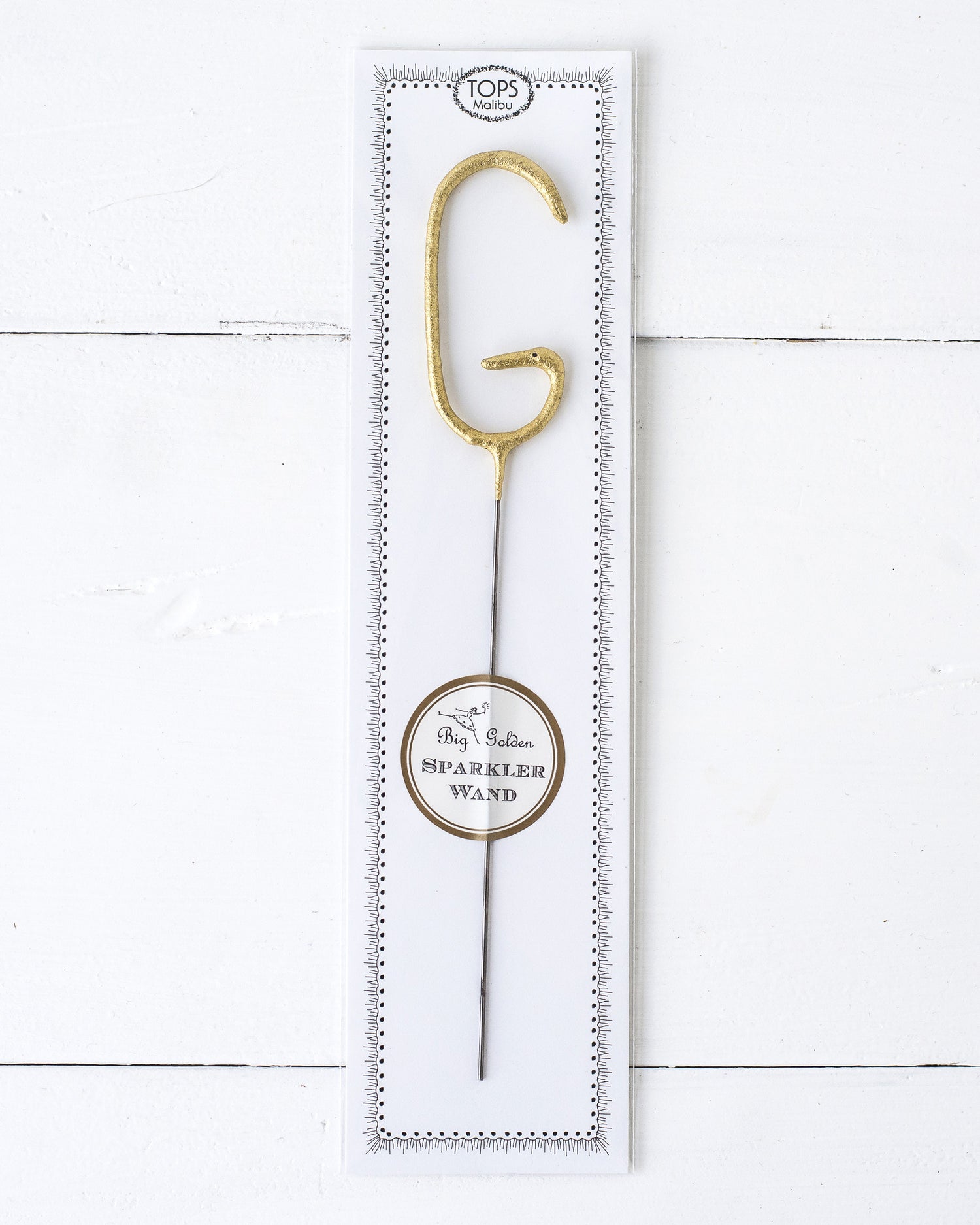 Three Tops Malibu gold Letter Sparklers on a wooden surface.