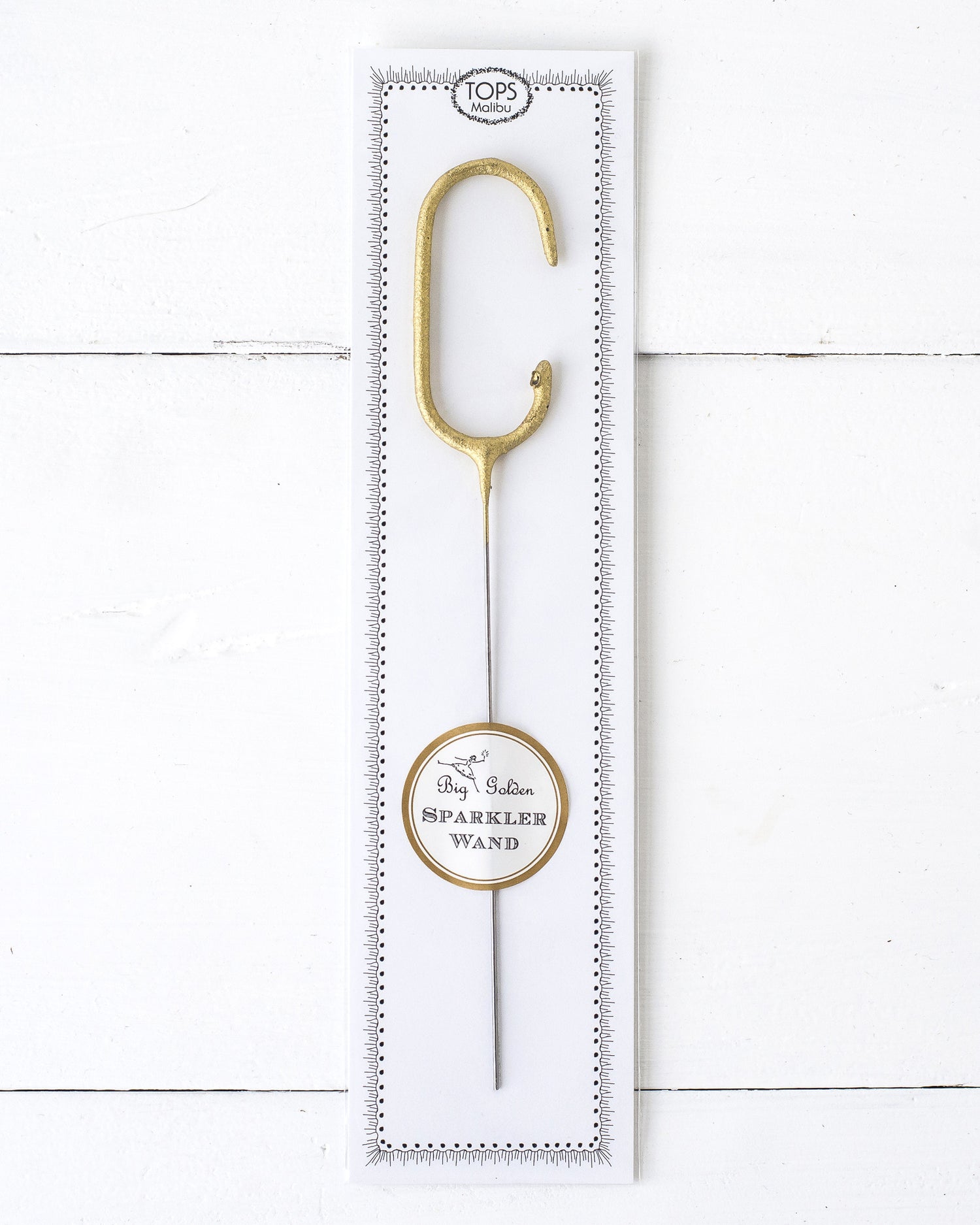 Three Tops Malibu gold Letter Sparklers on a wooden surface.