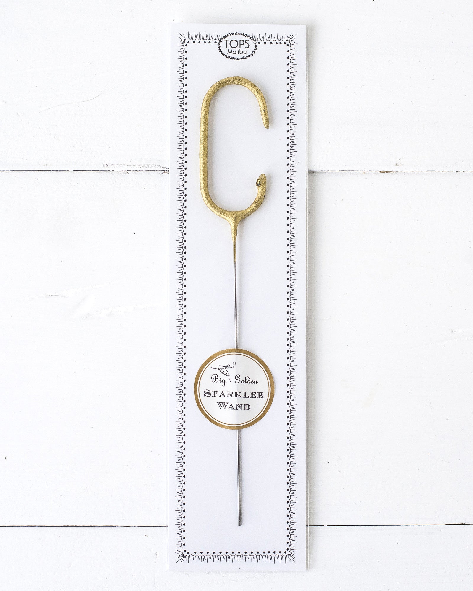 Three Tops Malibu gold Letter Sparklers on a wooden surface.