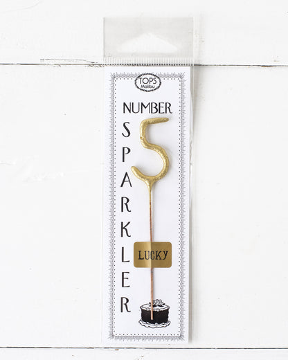 A 4&quot; tall Gold Number Cake Topper Sparkler with the number 5 on it, perfect for an instant party from Tops Malibu.