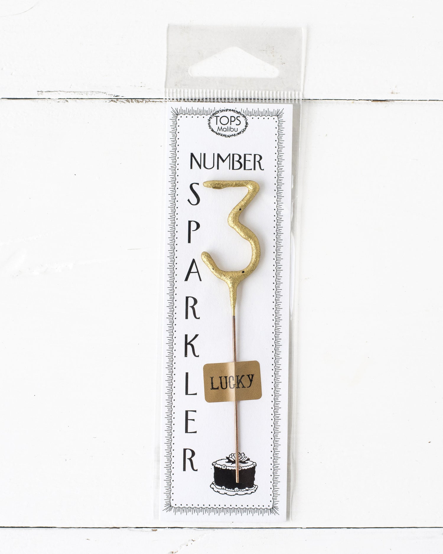 A Gold Number Cake Topper Sparkler, 4&quot; tall, illuminating an instant party on a white background by Tops Malibu.