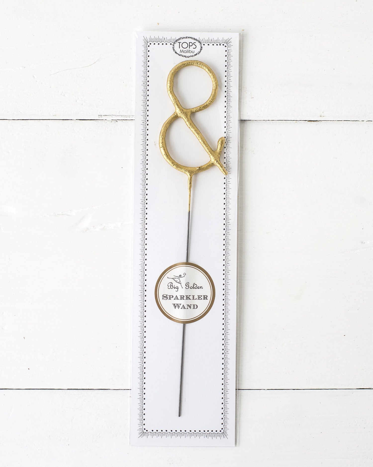 Three Tops Malibu gold Letter Sparklers on a wooden surface.