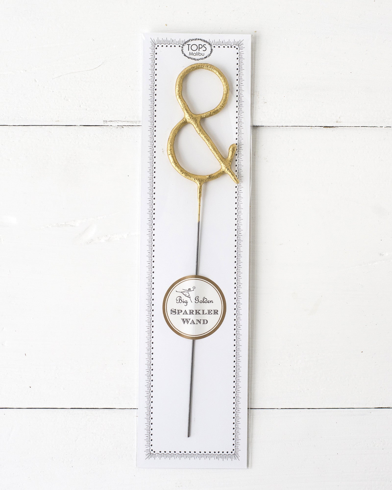 Three Tops Malibu gold Letter Sparklers on a wooden surface.