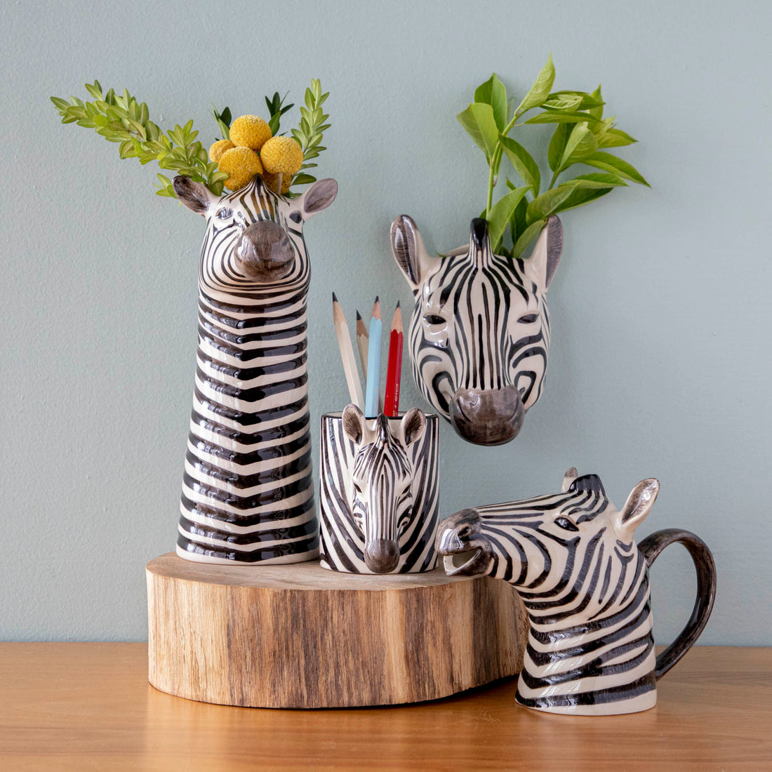 A set of Quail zebra ceramic vases on a wooden table.