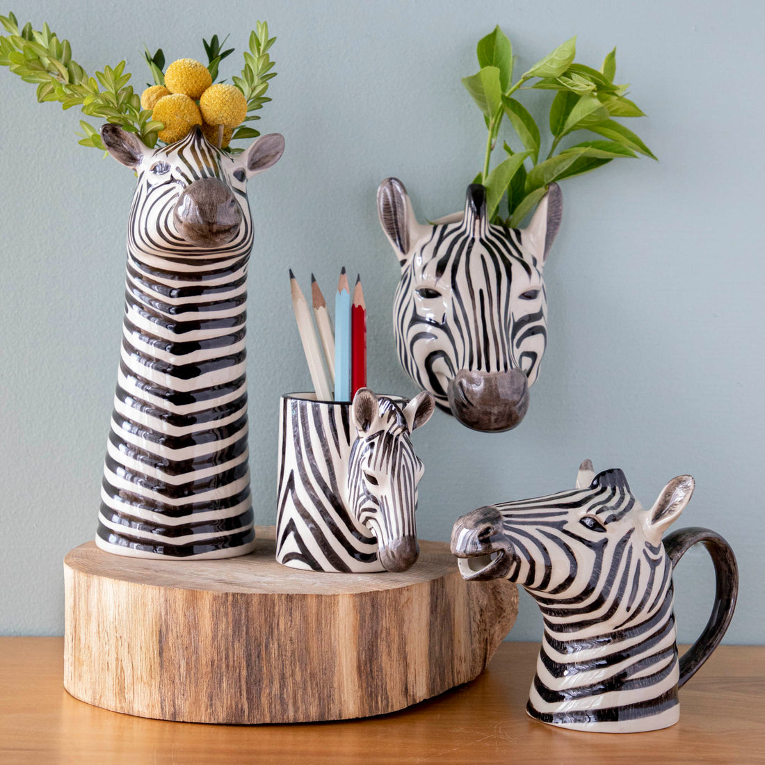 A set of Quail zebra ceramic vases on a wooden table.