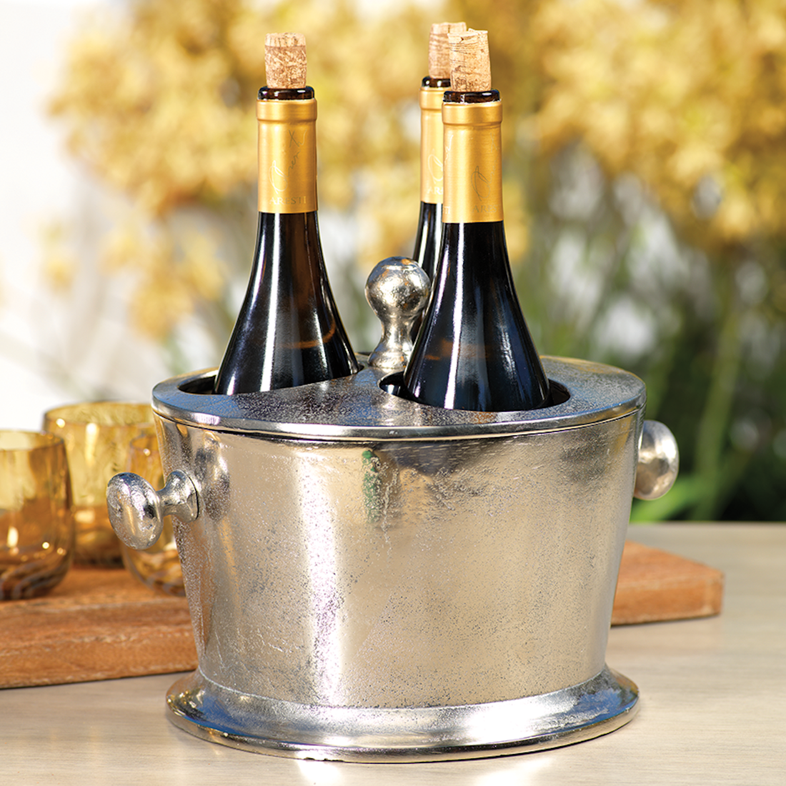 Two bottles of French wine chilling in a Zodax Three Bottle Wine Holder in Silver 10&quot; Tall with a blurred natural background.