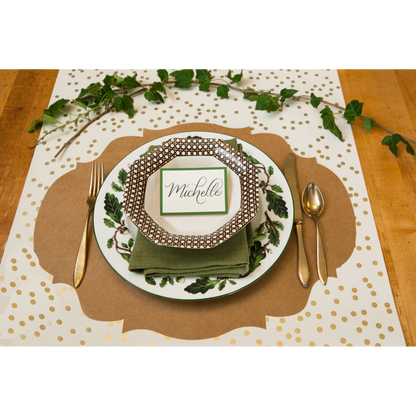 A Hester &amp; Cook Dark Green Frame Place Card with a plate, silverware and napkin for guests at a buffet.