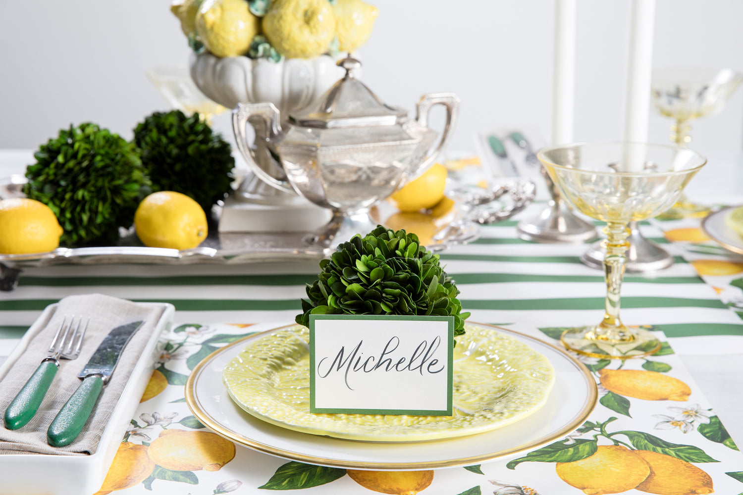A meticulously assembled table setting with Preserved Boxwood Sphere from Accent Decor and lush greenery.