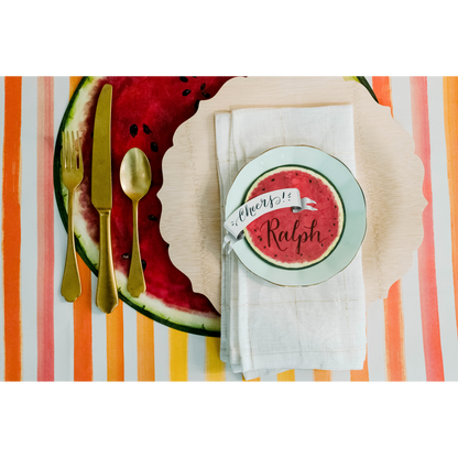 Top-down view of a vibrant summertime place setting, with a Banner Place Card reading &quot;Cheers!&quot; laying flat on the plate.