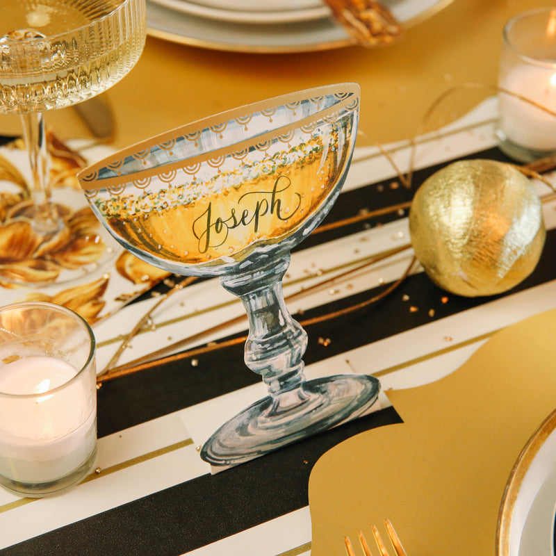 A Champagne Coupe Place card reading &quot;Joseph&quot; on a festive New Year&