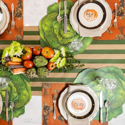 The Kraft Green Classic Stripe Runner under an rustic vegetable-themed table setting for four, from above.