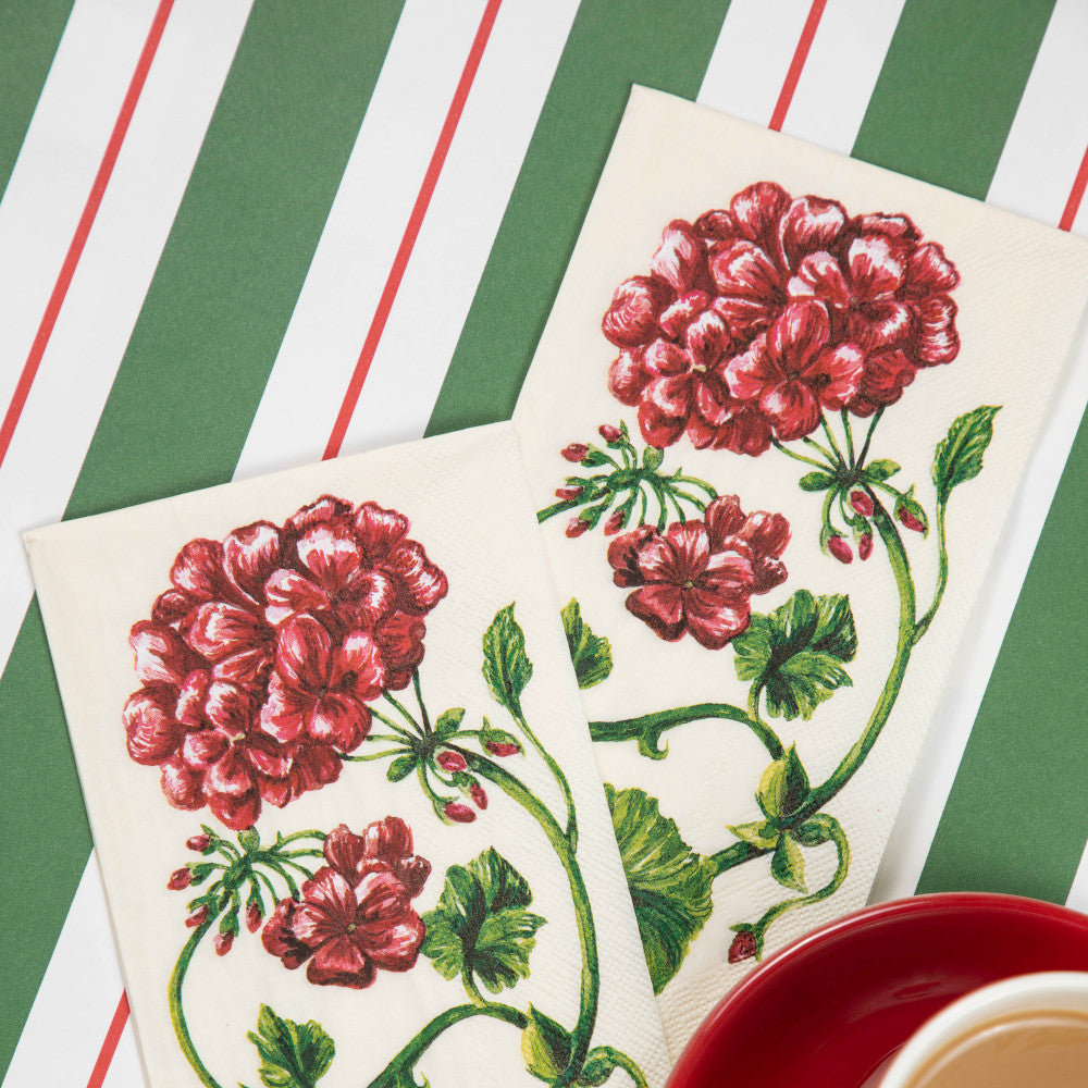The Green &amp; Red Awning Stripe Runner under a Christmas-themed place setting with a cup of coffee.