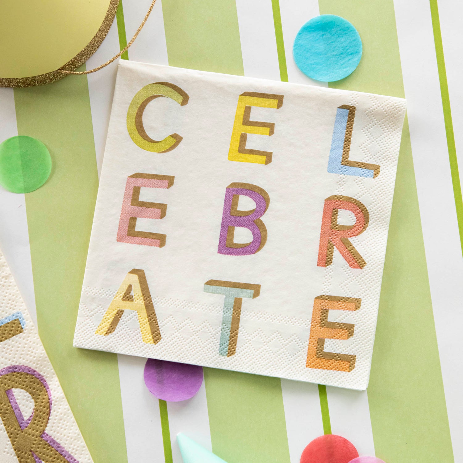 A Celebrate Cocktail Napkin on a festive table setting, from above.