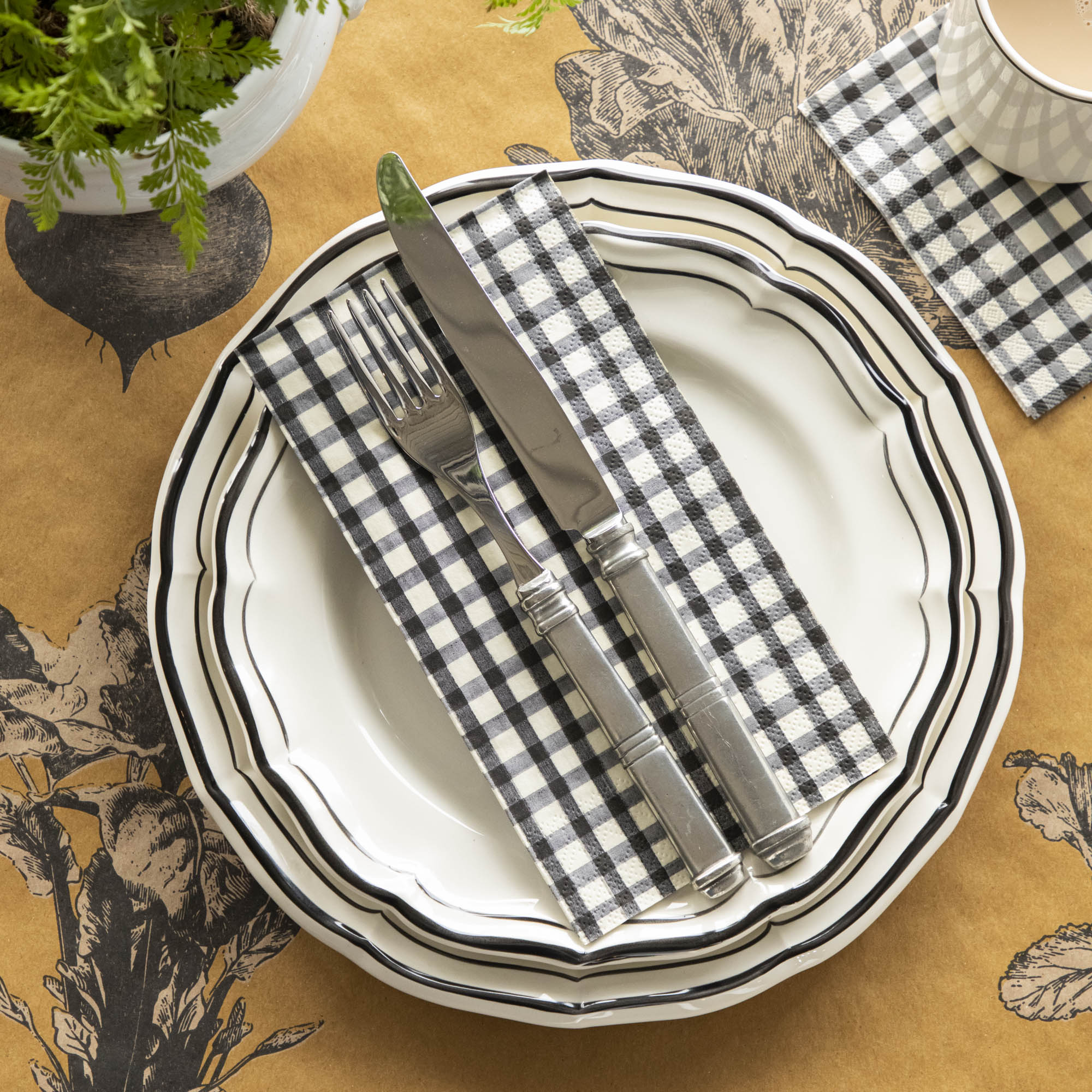 An elegant fall table setting with a Black Painted Guest Napkin on a plate with cutlery on top, and a Black Painted Cocktail Napkin under a coffee cup.