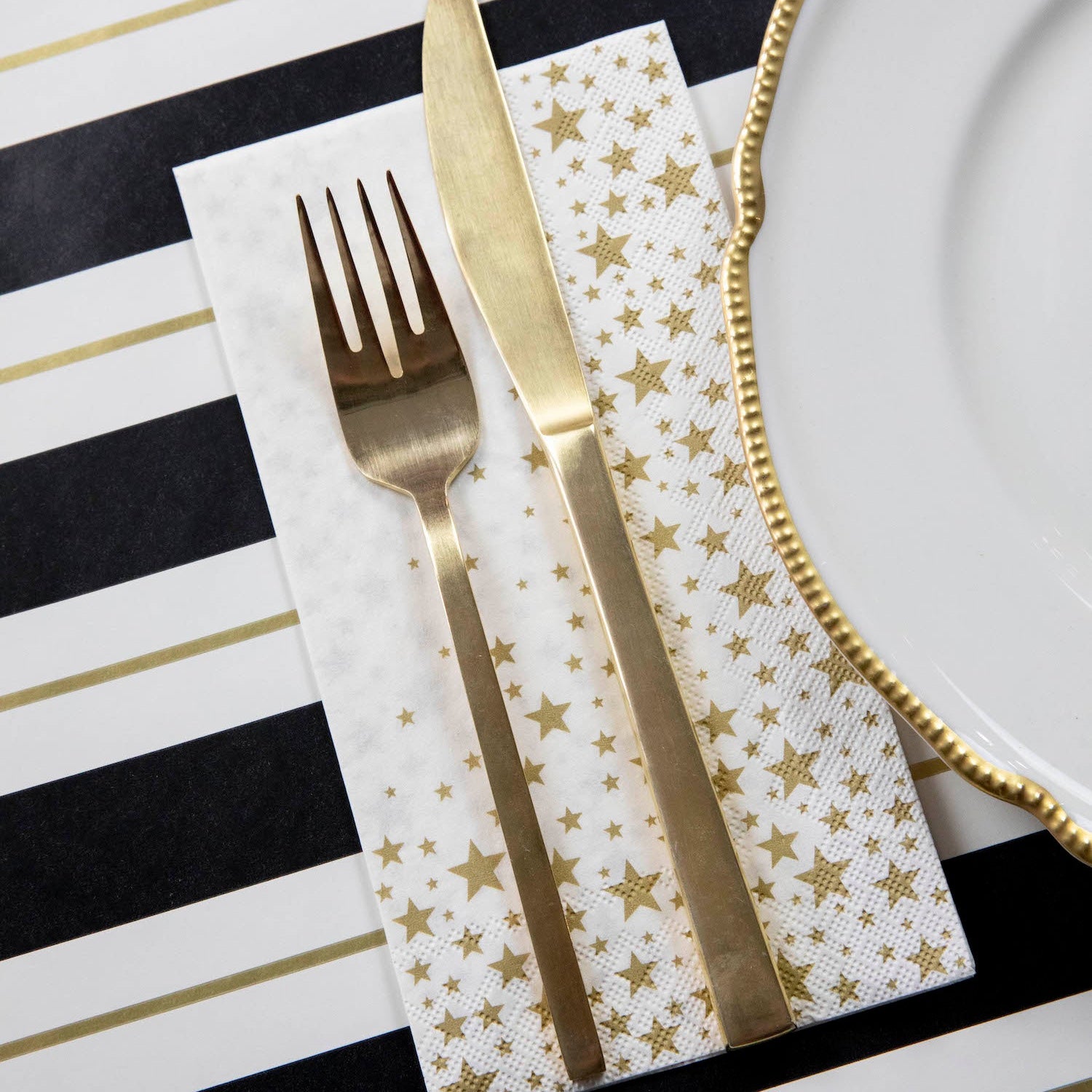 An elegant place setting with a Shining Star Guest Napkin next to the plate.