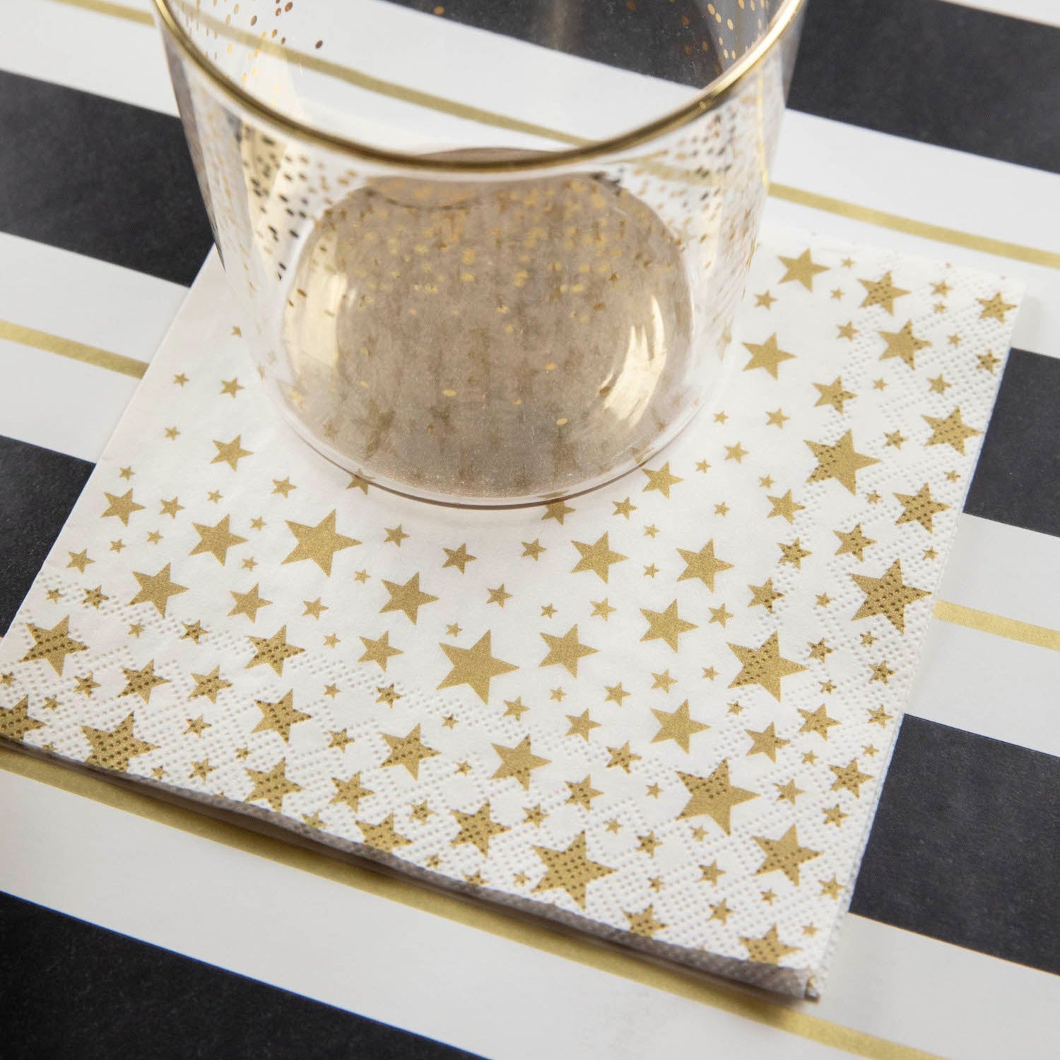 A Shining Star Cocktail Napkin under the water glass of an elegant place setting.