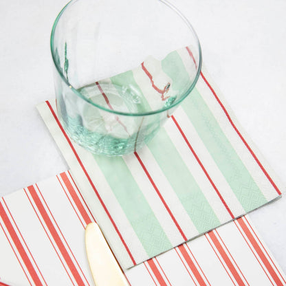 A Seafoam &amp; Red Awning Stripe Cocktail Napkin in an elegant place setting.