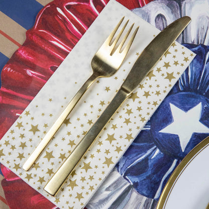 A Shining Star Guest Napkin under the fork and knife of a patriotic place setting.