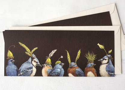 A dark brown greeting card featuring a row of blue songbirds wearing flowers and botanicals as hats, with the included envelope tucked behind the card. 