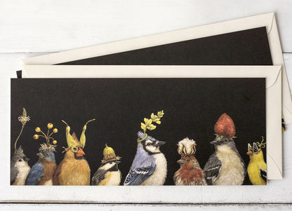 A dark brown greeting card featuring a row of songbirds wearing flowers and botanicals as hats, with the included envelope tucked behind the card. 