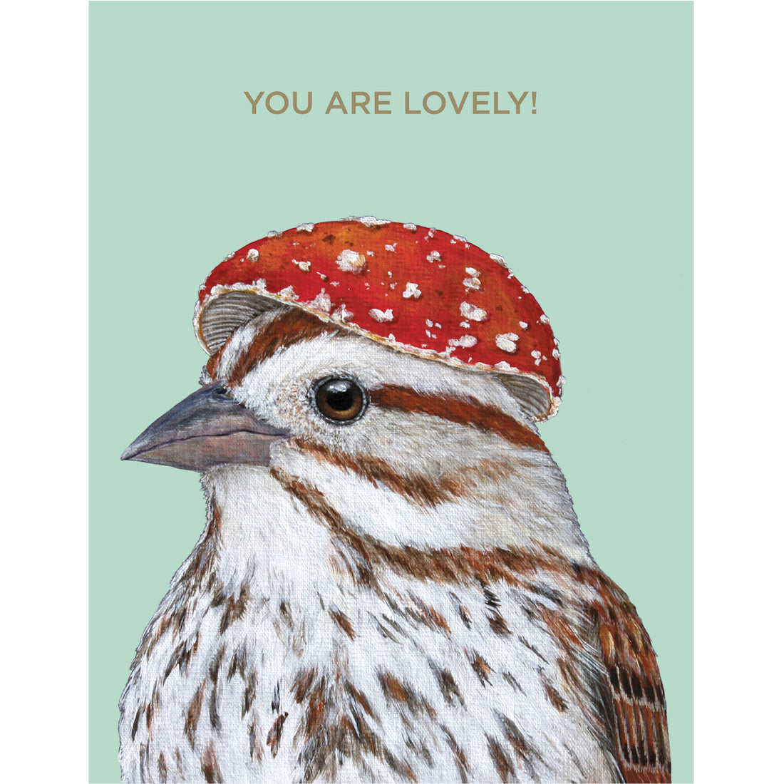 A seafoam greeting card featuring a charming illustration of a bird wearing a mushroom hat, with gold foil text reading &quot;YOU ARE LOVELY!&quot; across the top of the card.