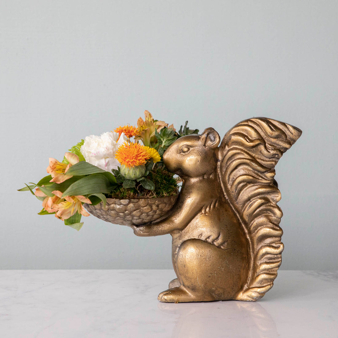 A bronze Accent Decor squirrel holding a bowl of moss.