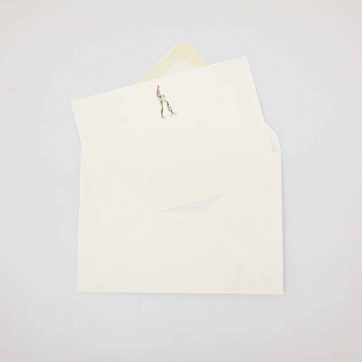 An illustrated Laura Stoddart note card tucked partway into a white envelope. 
