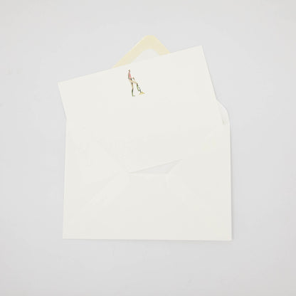 An illustrated Laura Stoddart note card tucked partway into a white envelope. 