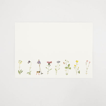 A white note card featuring a row of illustrated wildflowers across the bottom of the card, and a woman holding a rake. 