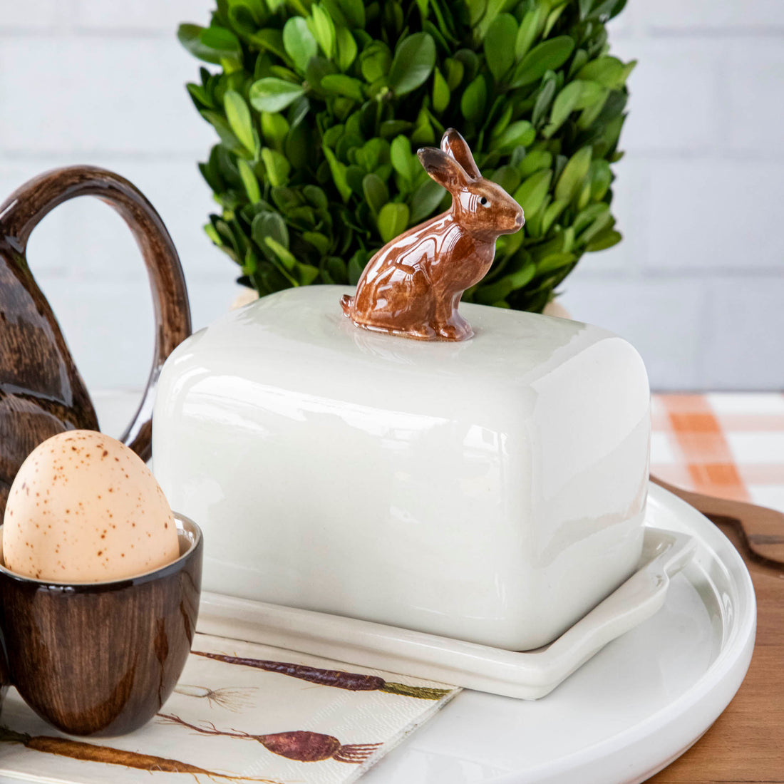 A hand-painted tray with two rabbits and an egg on it by British brand Hare Ceramics.