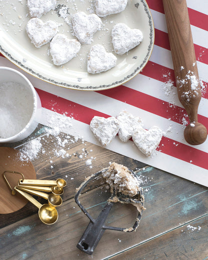 The Red Classic Stripe Runner on a table where cookies are being made.