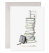 Greeting card with the illustration of a stack of books with a diploma at the top that says Happy Graduation by E.Frances. 