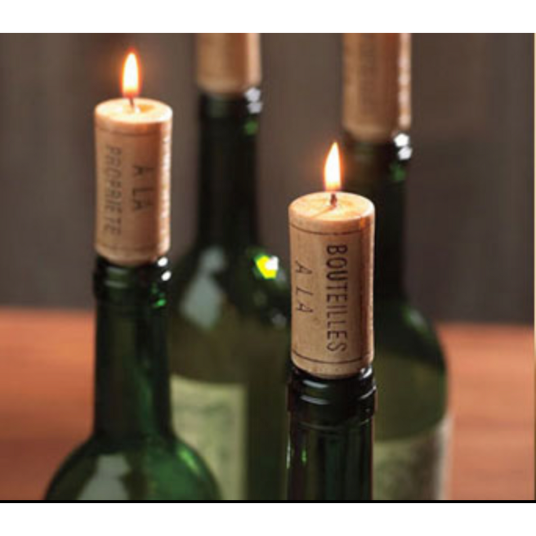 Candles shaped like wine corks in a bottle burning. 