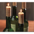 Candles shaped like wine corks in a bottle burning. 