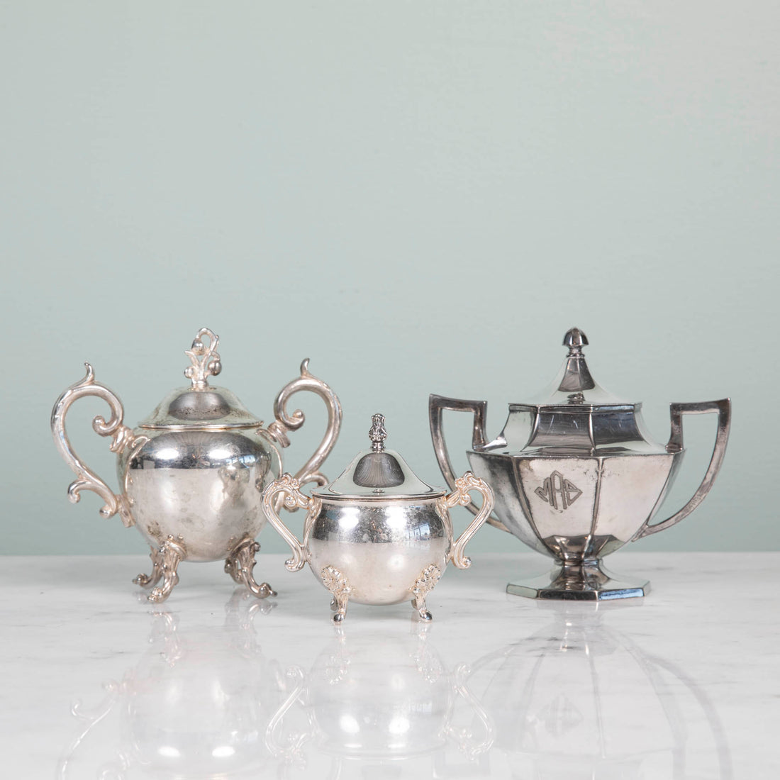 A Hester &amp; Cook vintage silver-plate sugar bowl on a pink tablecloth.