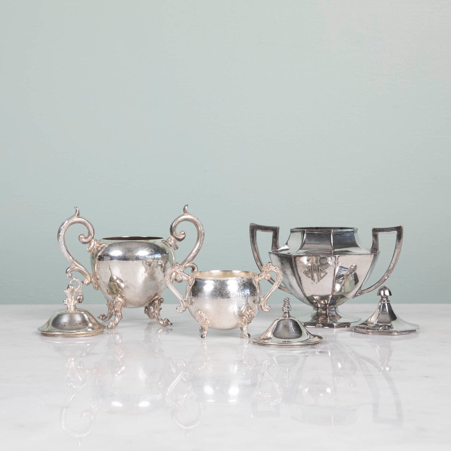 A Hester &amp; Cook vintage silver-plate sugar bowl on a pink tablecloth.